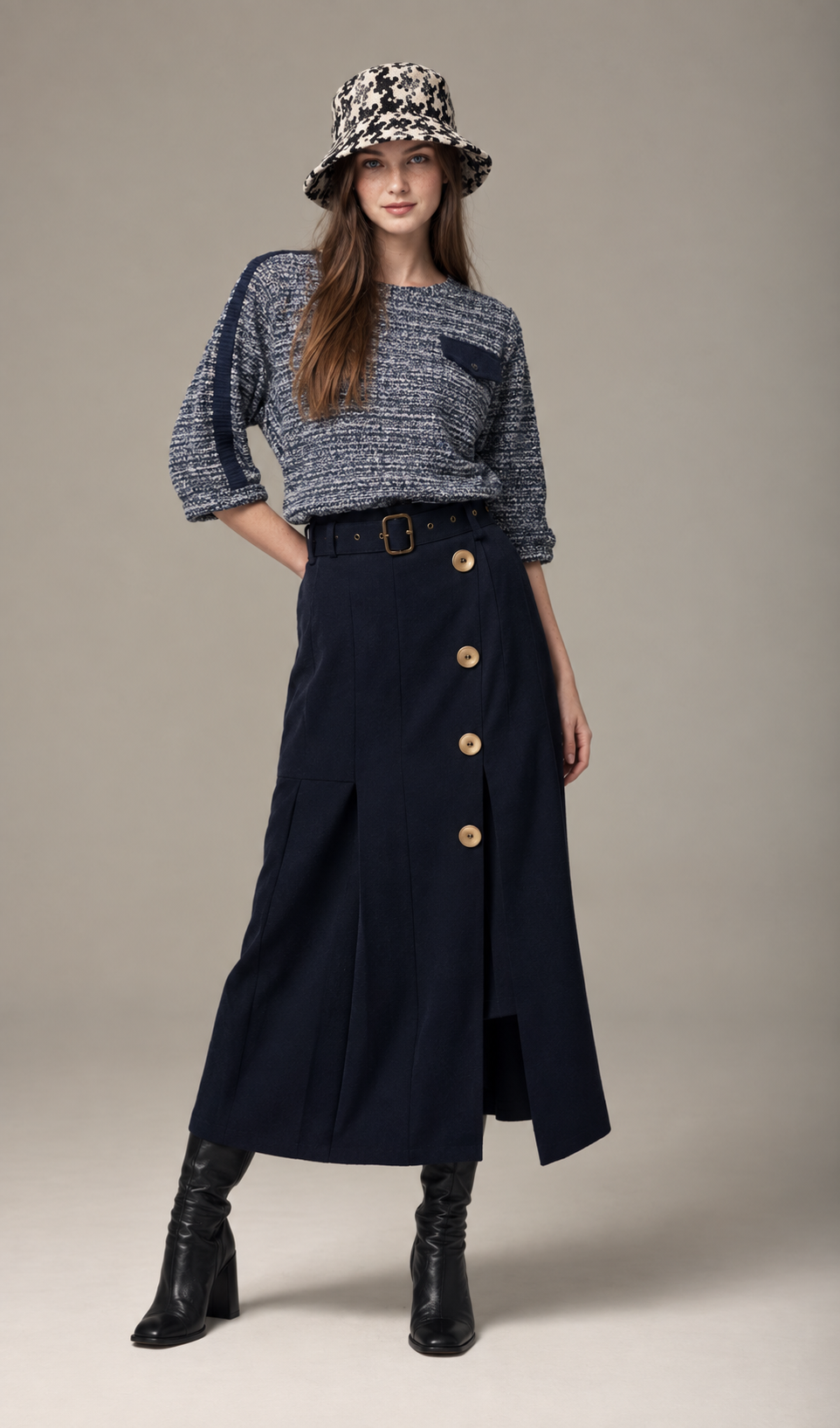 Model in a patterned bucket hat and navy button-front skirt