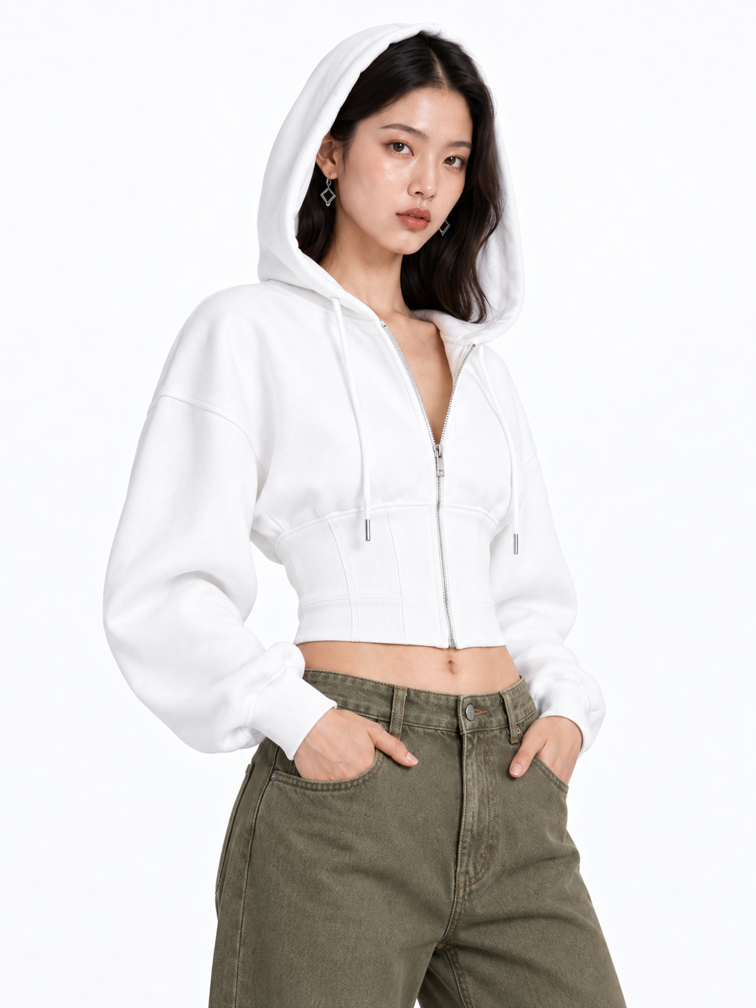 Fashion model wearing a white zip hoodie and olive trousers against a white background